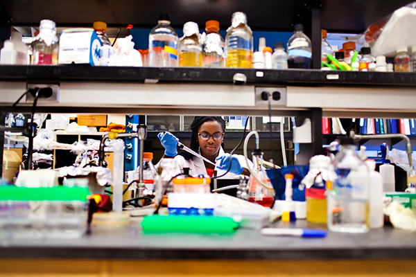 African-American student works diligently in a laboratory setting.