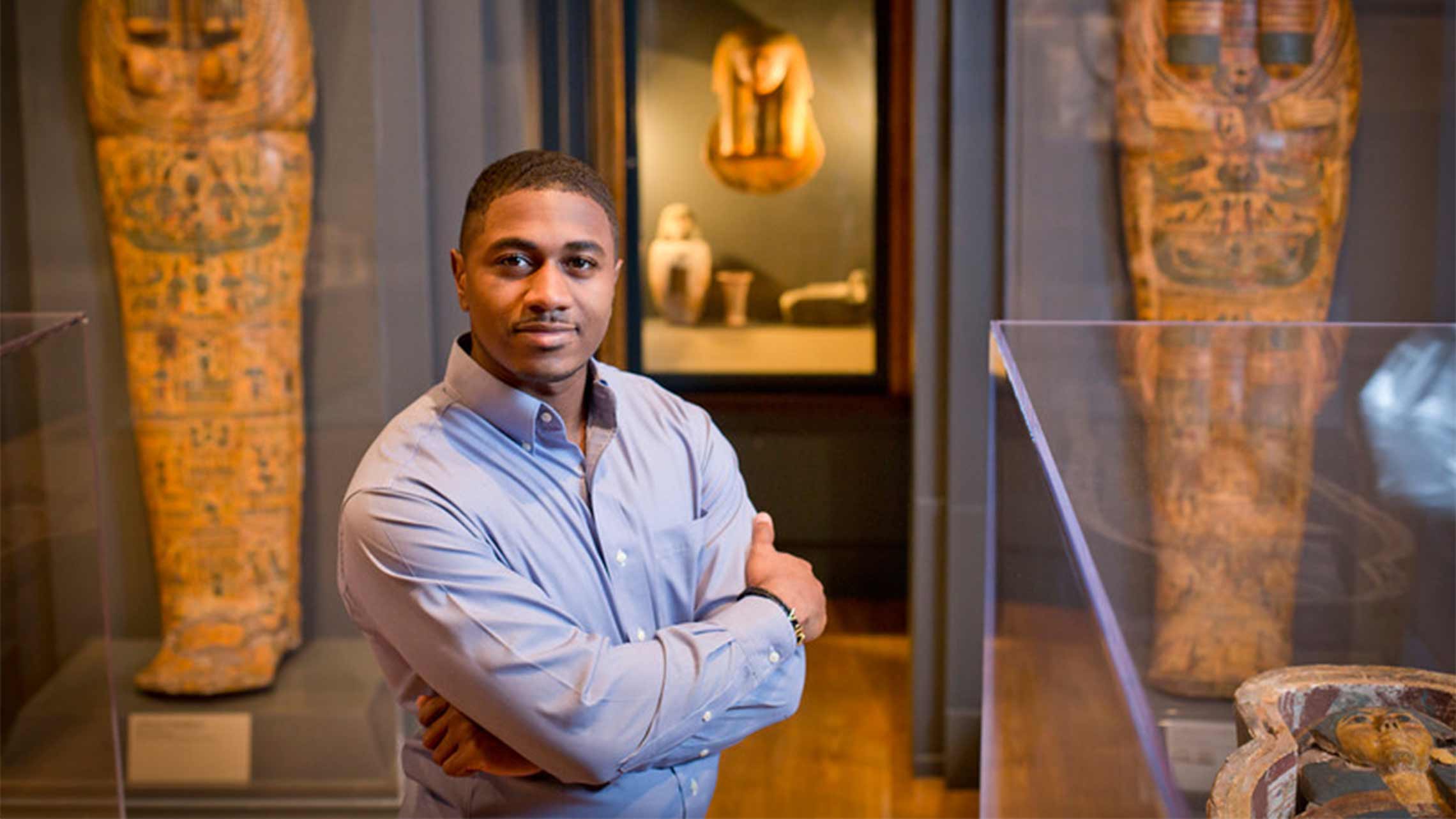 African American male poses in the Art Museum between two exhibits.
